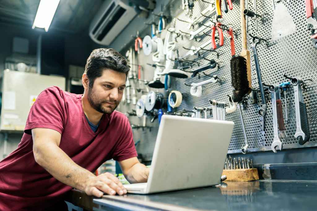 Business owner using laptop in tool store